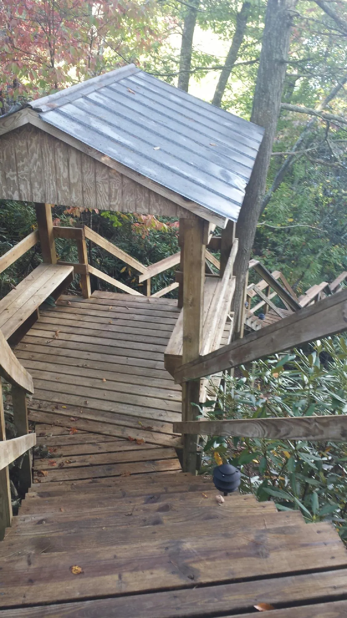 Metal roofed shelter over wooden steps on a wooded walkway — Skylight Repair & Installation work by our crew in Pocasset
